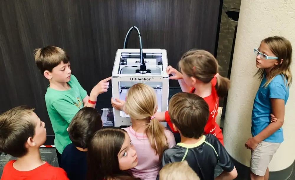 Children sitting on chair in front of table, illustrating educational robotics for children